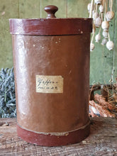 Load image into Gallery viewer, Antique German apothecary jar (brown with maroon stripes) on a rustic stool. It is styled with a black bucket of lavender and a vineyard basket against a sage green planked door.