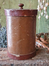 Load image into Gallery viewer, Antique German apothecary jar (brown with maroon stripes) on a rustic stool. It is styled with a black bucket of lavender and a vineyard basket against a sage green planked door.