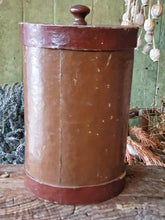 Load image into Gallery viewer, Antique German apothecary jar (brown with maroon stripes) on a rustic stool. It is styled with a black bucket of lavender and a vineyard basket against a sage green planked door.