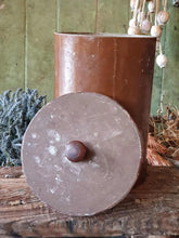 Load image into Gallery viewer, Antique German apothecary jar (brown with maroon stripes) on a rustic stool. It is styled with a black bucket of lavender and a vineyard basket against a sage green planked door.

