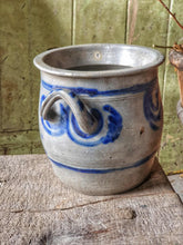 Load image into Gallery viewer, Grey and blue Betschdorf confit pot sitting on a low, weathered rustic farmhouse stool. In the background is a rustic farmhouse door painted in sage green, with sunlight streaming in from the left.