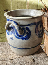Load image into Gallery viewer, Grey and blue Betschdorf confit pot sitting on a low, weathered rustic farmhouse stool. In the background is a rustic farmhouse door painted in sage green, with sunlight streaming in from the left.