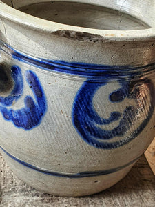 Ceramic pot with blue decorative patterns on a textured surface