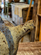 Load image into Gallery viewer, A close up of a rustic antique French cruche with a weathered beige and brown glaze, featuring a prominent spout and a blue gray painted section on the side, set against a blurred antique shop background.