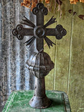 Load image into Gallery viewer, A dark metal Orthodox cross with a decorative ball finial and a central medallion, displayed on a green surface against a rustic green and gray background.