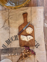 Load image into Gallery viewer, Antique French Rustic Farmhouse Bread Board Cutting Board sitting on top of a French Linen Flour sack on top of a primitive wooden french farm house table in the Dusty Gems Interiors Nanntwich shop 