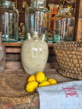 Load image into Gallery viewer, A 19th-century French walnut oil jar in buff terracotta with a thick cream tin glaze, showing a rustic, time-worn patina and simple provincial form.