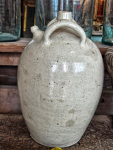 Load image into Gallery viewer, A 19th-century French walnut oil jar in buff terracotta with a thick cream tin glaze, showing a rustic, time-worn patina and simple provincial form.