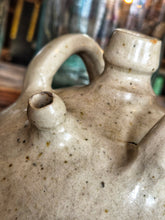 Load image into Gallery viewer, A 19th-century French walnut oil jar in buff terracotta with a thick cream tin glaze, showing a rustic, time-worn patina and simple provincial form.