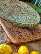 Load image into Gallery viewer, A heavy, hand-formed Moroccan Tamegroute footed serving dish with a soft cream ground and a delicate green splatter glaze. The shallow pedestal bowl features a rough, textured, salt-fired crystalline finish and is styled filled with bright lemons against a backdrop of weathered timber and rustic country-house furniture.