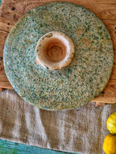 Load image into Gallery viewer, A heavy, hand-formed Moroccan Tamegroute footed serving dish with a soft cream ground and a delicate green splatter glaze. The shallow pedestal bowl features a rough, textured, salt-fired crystalline finish and is styled filled with bright lemons against a backdrop of weathered timber and rustic country-house furniture.