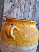 Load image into Gallery viewer, Antique French Large Confit pot Rustic Farmhouise mustard Glaze  Terracotta body sitting infront of french country primitive wooden shutters in the Dusty Gems interiors nantwich shop 