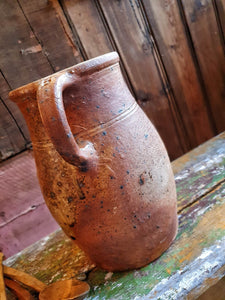 Antique French Country Rustic Cider Jug 19th Century Farmhouse sitting on antique Swedish painted farmhouse bench with antique handcarved spoons next to the Jug overall primitive farmhouse kitchen look Dusty Gems Interiors Nantwich