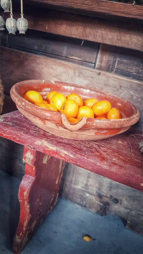 French Antique 19th Century Gassoutlet Dairy Bowl rustic Farmhouse provence pottery brown glazed terracotta sitting on red painted french farmhouse bench primitive wooden kitchen behind bowl is filled with oranges dusty gems interiors nantwich 