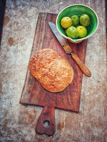 KFrench Antique  Country Farmhouse  Chopping Board on Antique  Rustic itchen primitive Table sourdough bread and bread knife French country pottery green glazed bowl with Limes Dusty Gems Interior shop Nantwich 