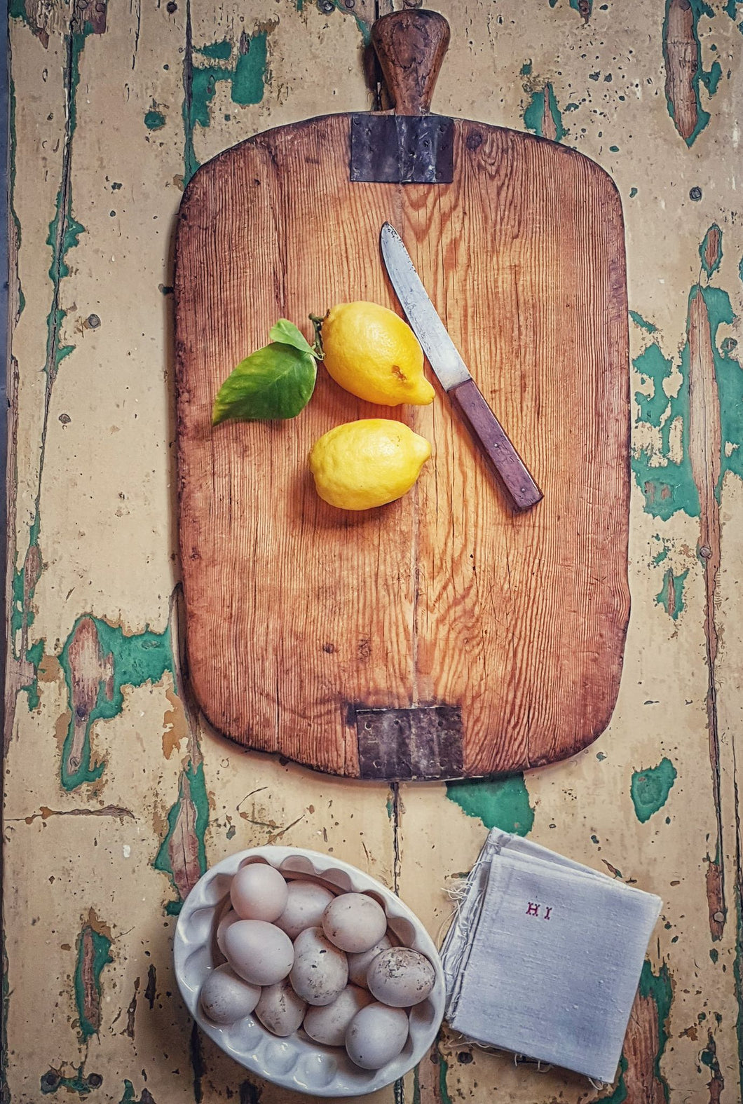 Antique French Farmhouse Chopping Board Rustic Charcuterie board with fresh lemons sitting on chippy paint french farmhouse table in green and yellow fresh duck eggs and antique french linen dusty gems interiors Nantwich antiques 